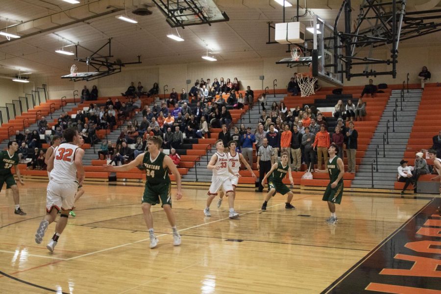 Brimming with anticipation, the players watch as a another basket is scored for LHS by Travis Clark.