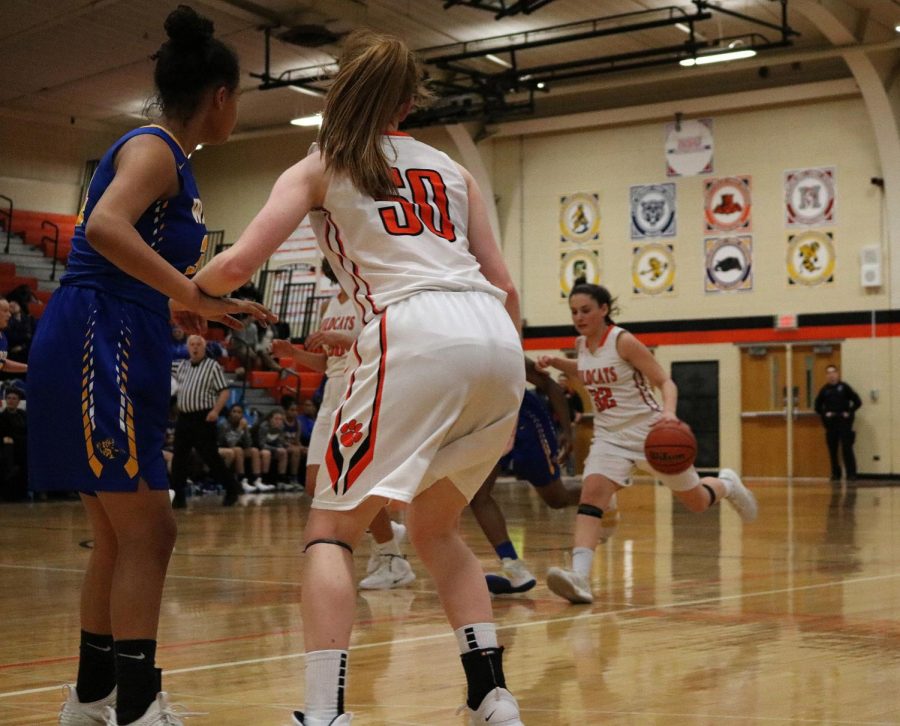 #50, junior Lydia Crow guards as her teammate, fellow junior Margaret Buchert #32 makes her way down the court.