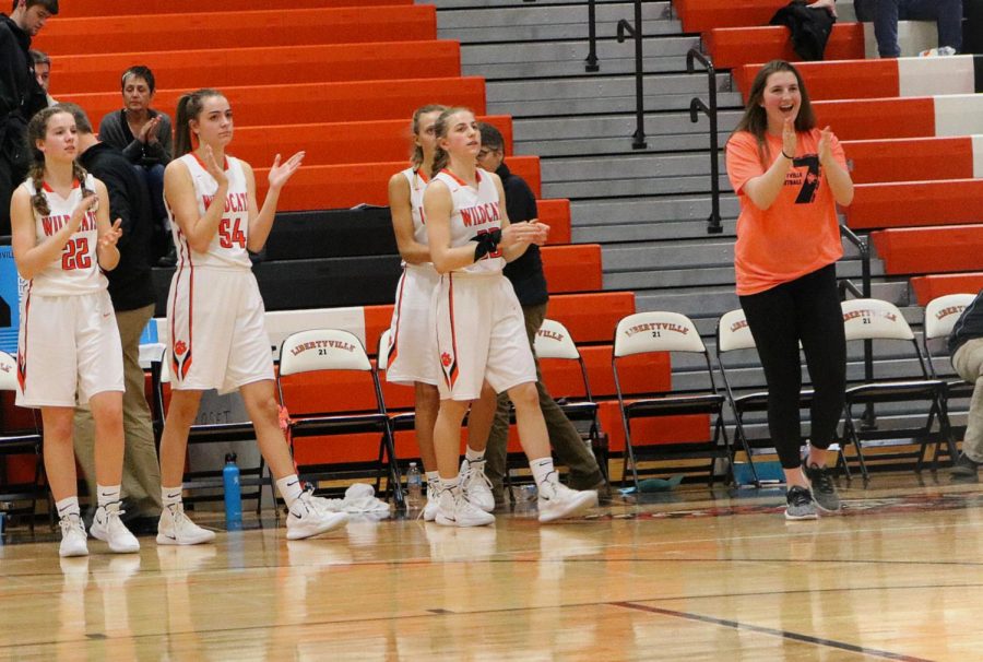 The team celebrates a victory over Warren with the final score ending 56-41.