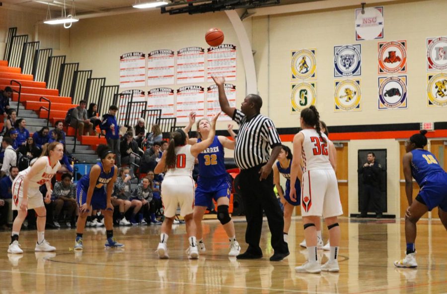 The referee tips off the start of the 'silent seven' game, where the audience remains completely quiet until the home team scores seven points, when they celebrate wildly.