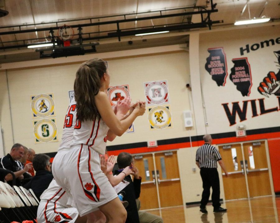 Teammates celebrate on the sidelines after a basket by Libertyville brings the score to 12-14 Warren.