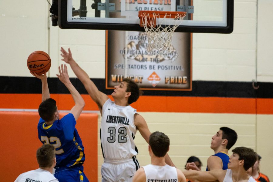 Senior captain Travis Clark contests a Warren layup, successfully blocking the ball and gaining some momentum for Libertyville.