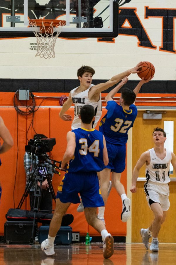 Making a big block to switch possession late in the game, Graham (20) towers over his opponent.