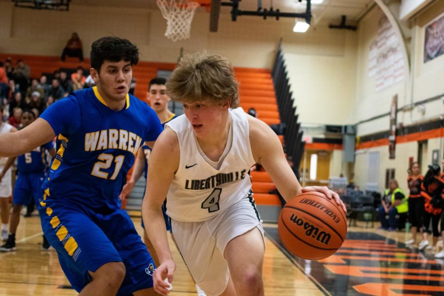 Moore dribbles out of pressure to look for an open teammate.