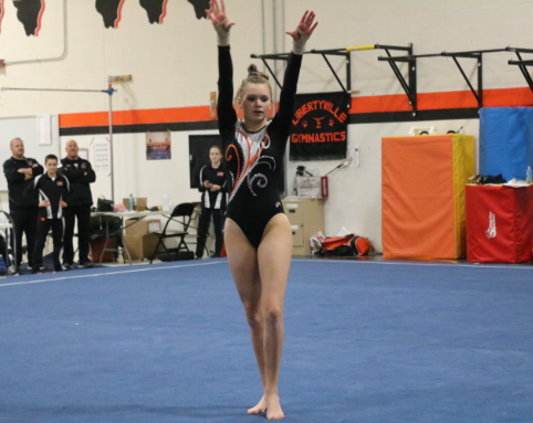 Grace Neuberger poses right after beginning her floor routine and going into a turn.