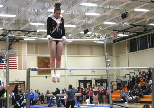 Swanson prepares to do a flip on the uneven bars.