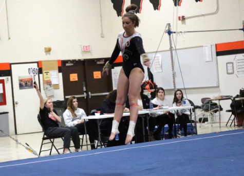 Junior Maddie Swanson prepares to land as she goes through her floor routine.