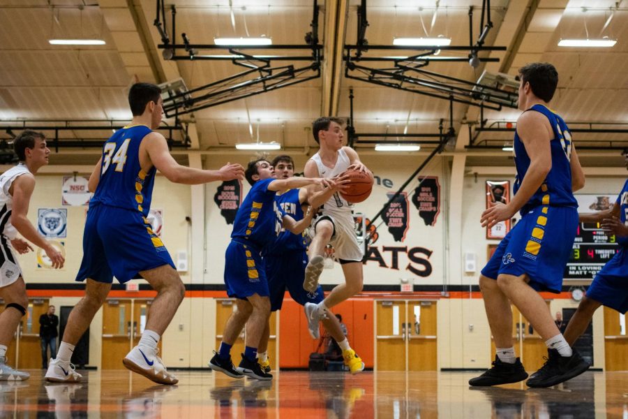 Surrounded by Warren defenders, Steinhaus tries to kick the ball back out to a teammate on the three-point line.