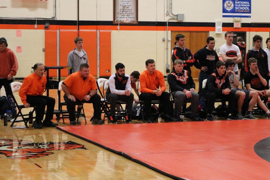 While wrestling, each competitor receives support and shouts of advice from the rest of the team -- coaches and athletes -- on the sidelines.