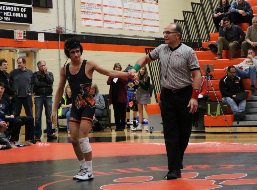 Freshman Caelan Riley is victorious in his match after pinning his competitor.