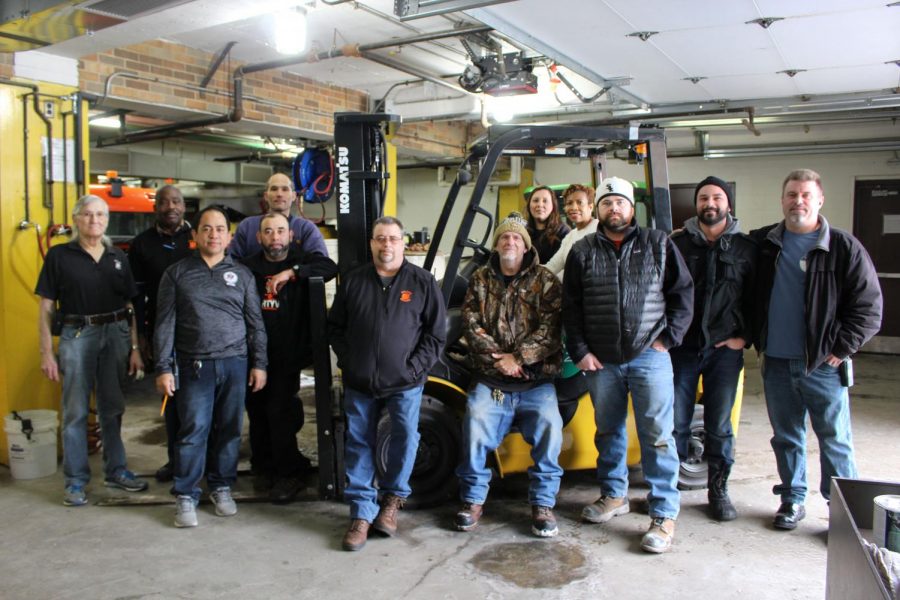 Pictured, from left to right, is the Building and Grounds crew: Roy Sims, Lewis Jones, Allan Engresso, Bernarve Ramirez, Danny Bennett, Ron Curtis, Gary Miller, Sinthia Zurek, Ruth Vasquez (secretary), Dan O'Connor, Marco Piacenza, and Chris Stancil