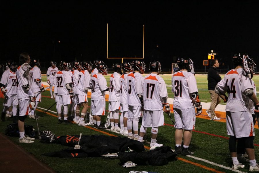 The non-playing team members and coaches watch intently from the sidelines.