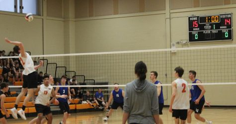 Wecik jumps up for a kill while his teammates look on in the first set.