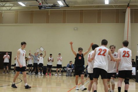 Teammates congratulate outside hitter Alex Weick (22) after a spike.