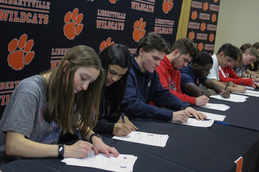 The+seniors+collectively+sign+their+letters+of+intent.