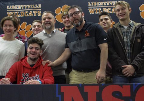 Christopher Boyle, committing to Lewis University for lacrosse, laughs with family and friends after signing his letter of intent. 