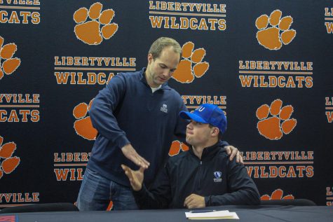 Dylan Drumke shakes hands with one of his coaches, Tim Matheson, after signing