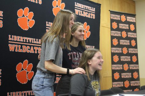 Isabella Zalewski, who committed to DePauw University for lacrosse, smiles besides her friends after signing her letter of intent.