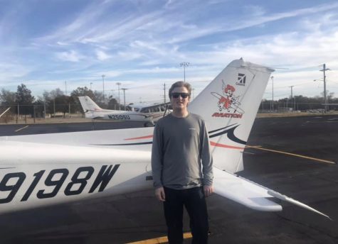 Senior Bradley Larsen has been flying for awhile and has been searching for universities based on their aviation program. Here, he is shown at the University of Oklahoma standing next to one of their many planes.