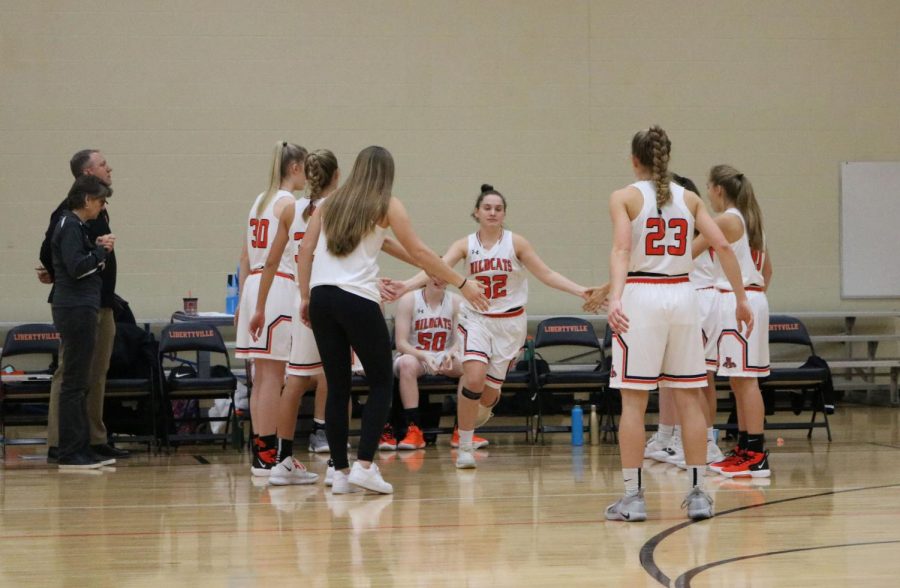 Before the game, the girls in the starting lineup are announced and do a choreographed handshake with Marianna Morrissey (23). Pictured here is Margaret Buchert (32) being cheered on by her team as her name is called.