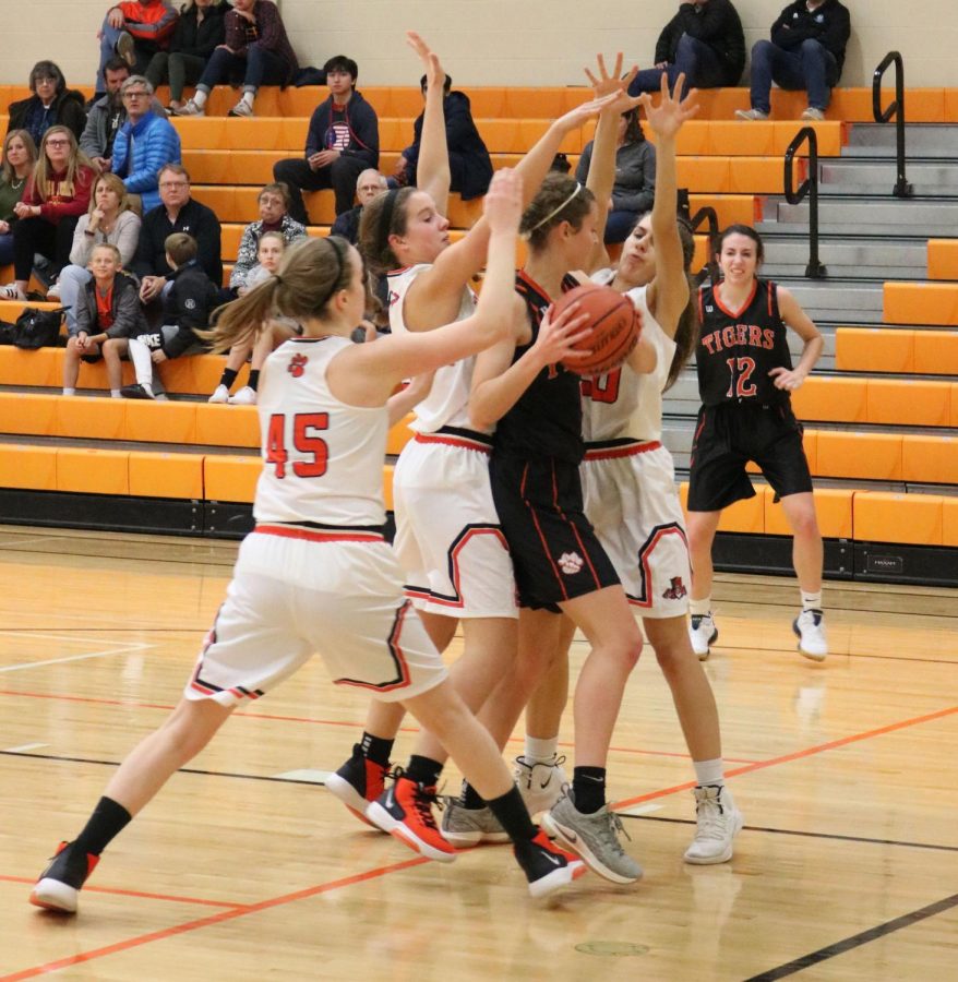 Three Wildcat defenders block their opponent after she gets the rebound, preventing her from passing.