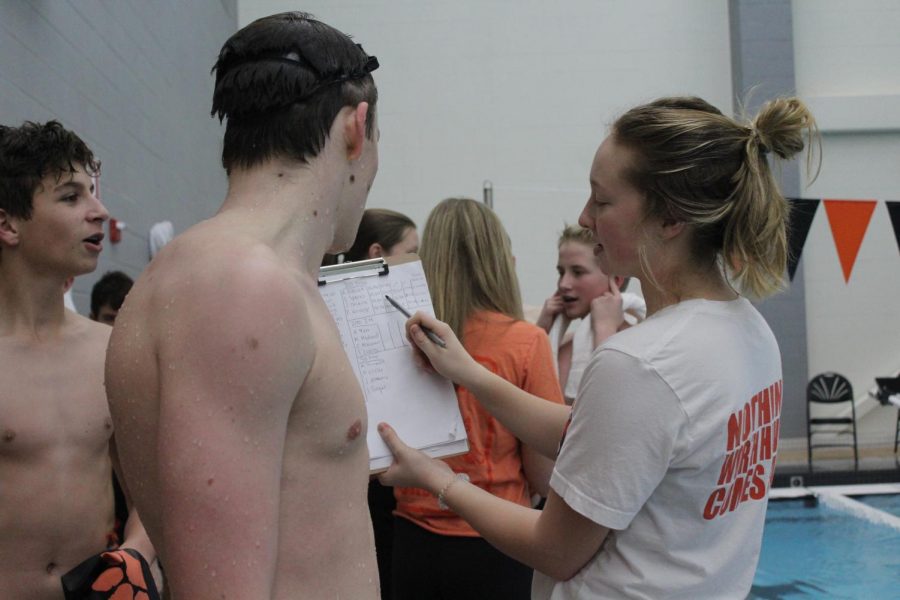 Varsity team manager Sarah Bennett (a Drops of Ink staff member) shows freshmen Eric Sparks his splits after his race.