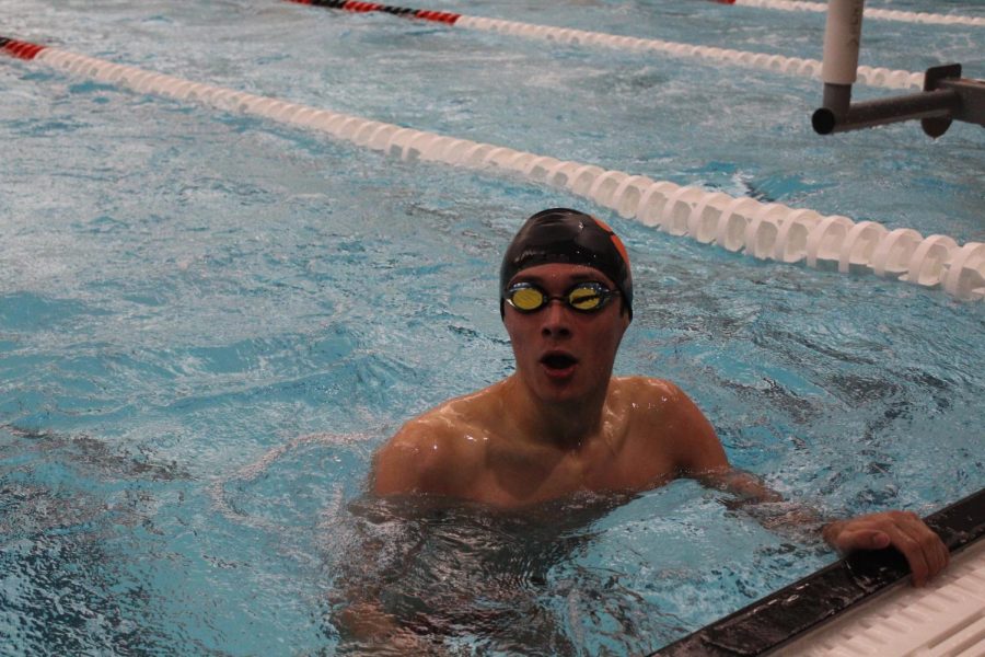 Senior Mark Plunkett looks up at the scoreboard following his first-place finish in the 50-yard freestyle.