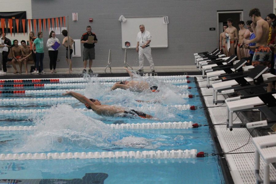 JV swimmers perform a backstroke start to kick off the 200-medley relay.