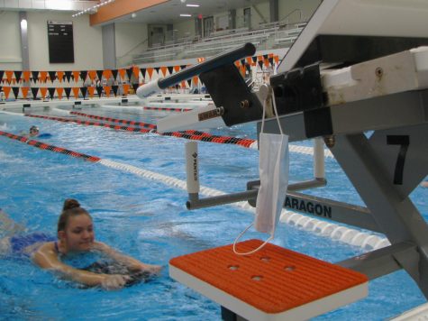 A mask hangs on one of the start blocks, as COVID-19 guidelines require swimmers to put on a mask immediately after getting out of the pool.