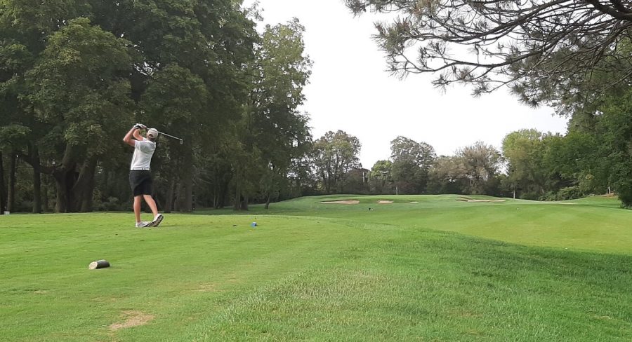 Senior Danny Keating watches his drive down the eighth hole, a par three.
