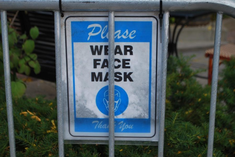A sign on the barrier of Firkin’s new outdoor seating reminds customers to wear a face covering. Similar signs can be found in the windows of many businesses around town.