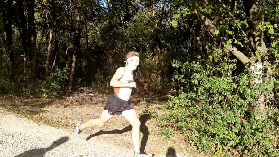 Senior Ethan Hanson passes the one-mile mark on the Adler Course.