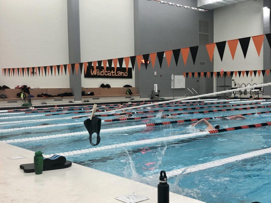 The boys swim team starts practice by hanging their masks on strings before getting in the pool, in order to follow guidelines set by the IHSA.