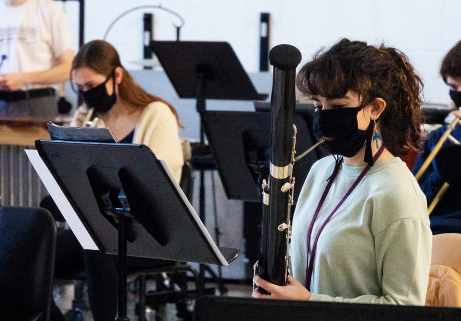 Band students, like Alyssa Abou Chakra, wear masks and have instrument covers to limit the risk of COVID.