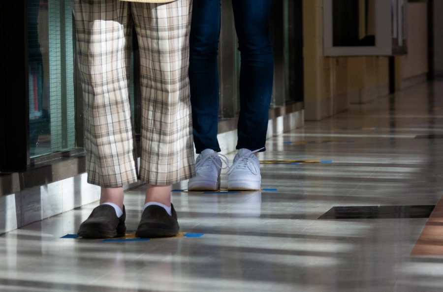 In order to avoid close gathering, spaces such as the library have social distancing markers outside, set six feet apart to give students designated spaces to stand while waiting.