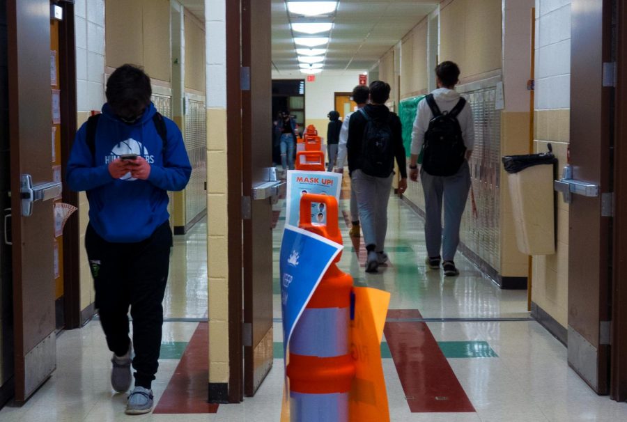 Students+pass+each+other+on+opposite+sides+of+the+hallway%2C+making+sure+to+follow+the+barrier+set+in+place+by+social+distancing+cones.