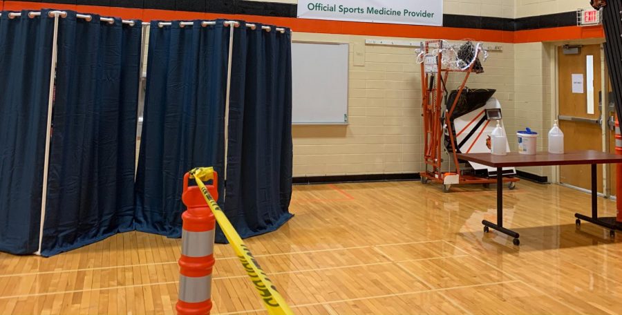 After taking their tests behind the curtain, those who tested exit the gym through one door, using hand sanitizer before they leave.