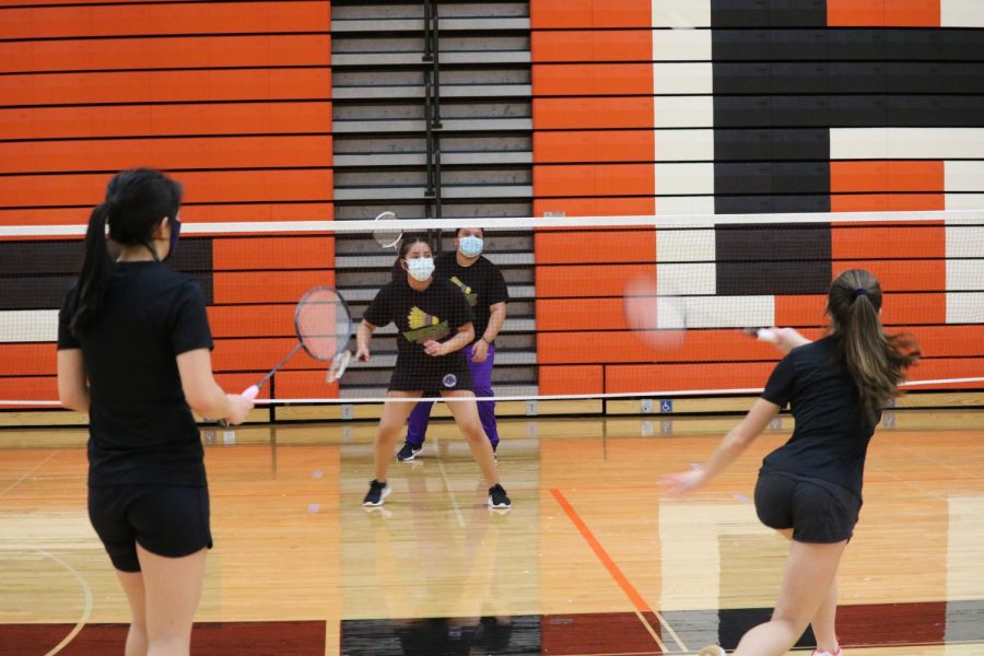 Alexandra Berns smashes the birdie across the net while her doubles partner Kathleen Jin stands ready for the return.