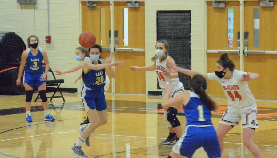 Lake Forest’s #30 passes to her teammate while the Cats defend.