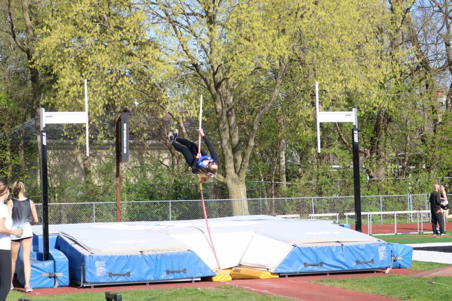 A Lake Zurich pole vaulter practices her jump without the bar early in the meet to warm up.