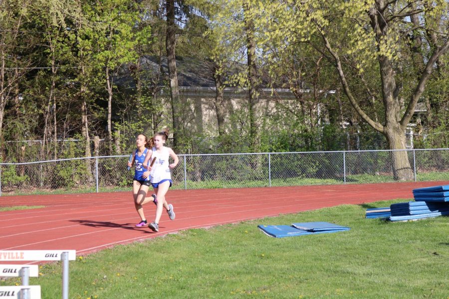 A Lake Zurich runner overtakes a Lake Forest runner around the curve of the oval track on their leg of the 4 x 800 meter relay race.