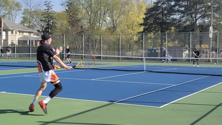 Wils Warren darts to the right to complete a forehand volley.