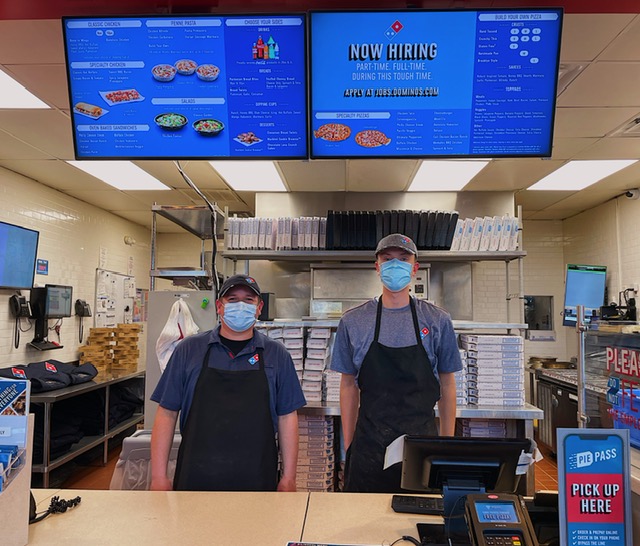 Edder (on the left), the Domino’s manager, encourages people to apply to work at the restaurant, as they are hiring. Brian Brzezinski (on the right) is a Domino’s employee standing next to him. 