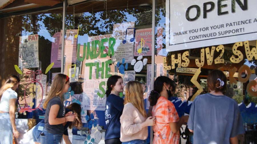 The junior varsity 2 girls swim team decorate their window. 