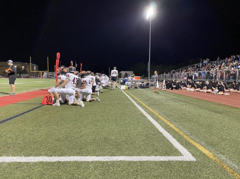 The team kneels as their quarterback Connor Dickson is down on the field. 