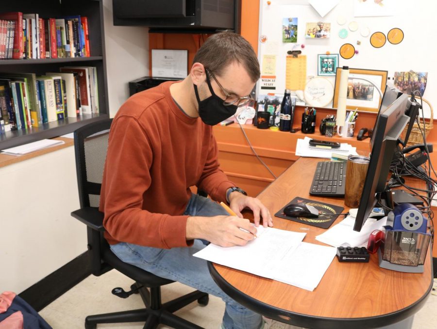 English teacher Ryan Ebling grades student assignments while utilizing new grading practices. He is using a rubric that grades students on a scale from one to five.