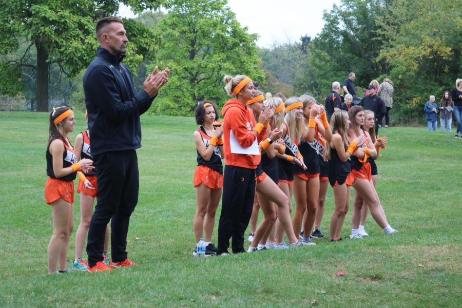 Athletic Director John Woods and the girls team cheer on the boys cross country team during their race. 