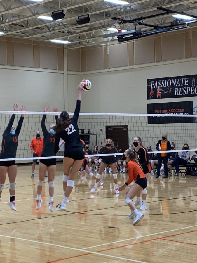 Keira Kasten (22) flies above the net for a spike.