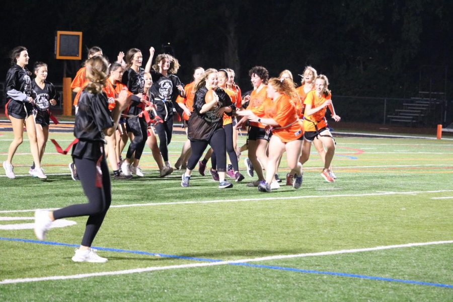 Libby Karston runs down the field while her team cheers her along.