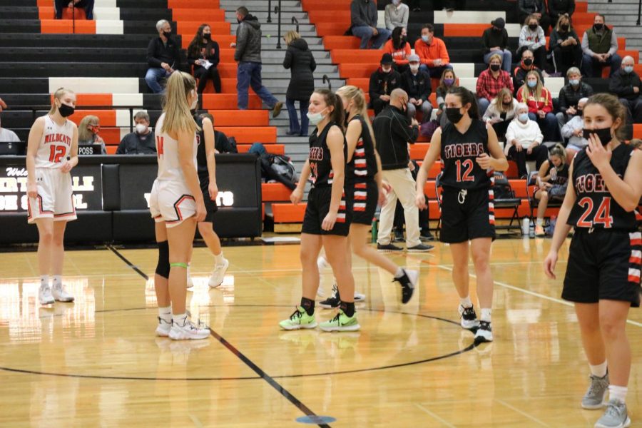 The girls line up at the midcourt line getting ready for the tip off to start off a competitive, physical game.